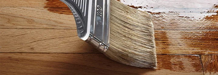 Pinsel trägt Lack auf Holz auf